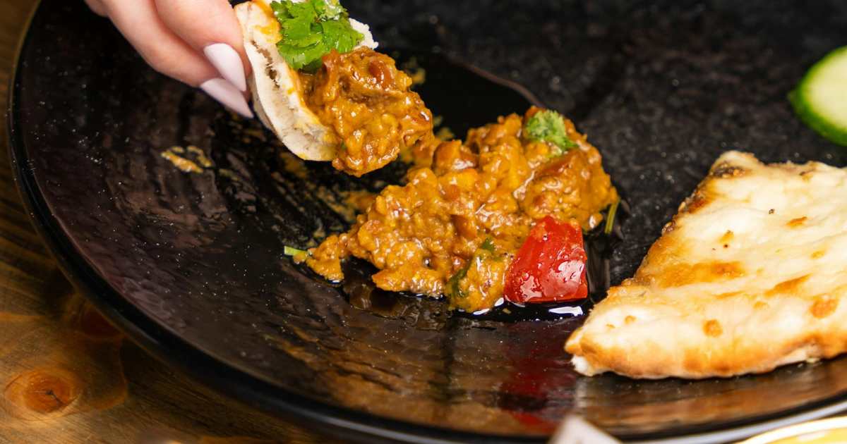 Woman's hand over food on plate - Representative Image Source: Pexels | Ali Dashti