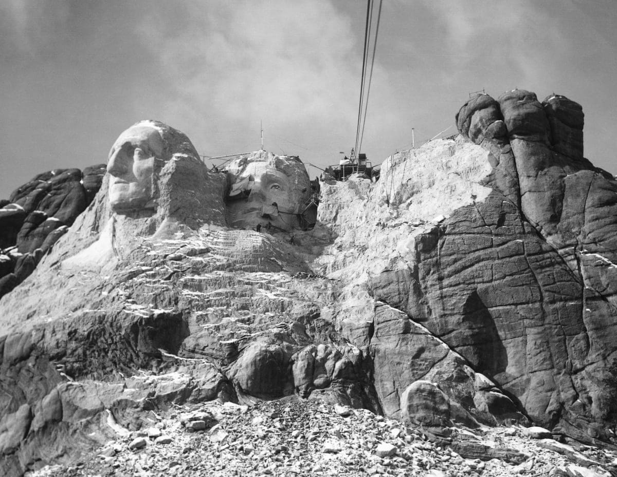 Image Source: Mt. Rushmore, SD: The Head of Washington, Jefferson and the beginning of Lincoln as seen from the cable. (Photo by Bettman / Getty Images)