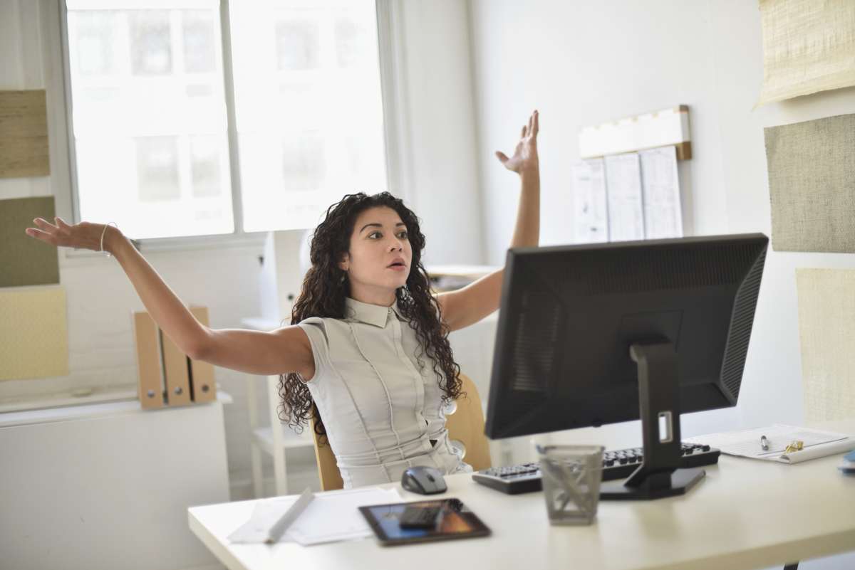 Woman frustrated at computer at desk in office - Representative Image Source: Getty Images | Photo by JGI/Tom Grill