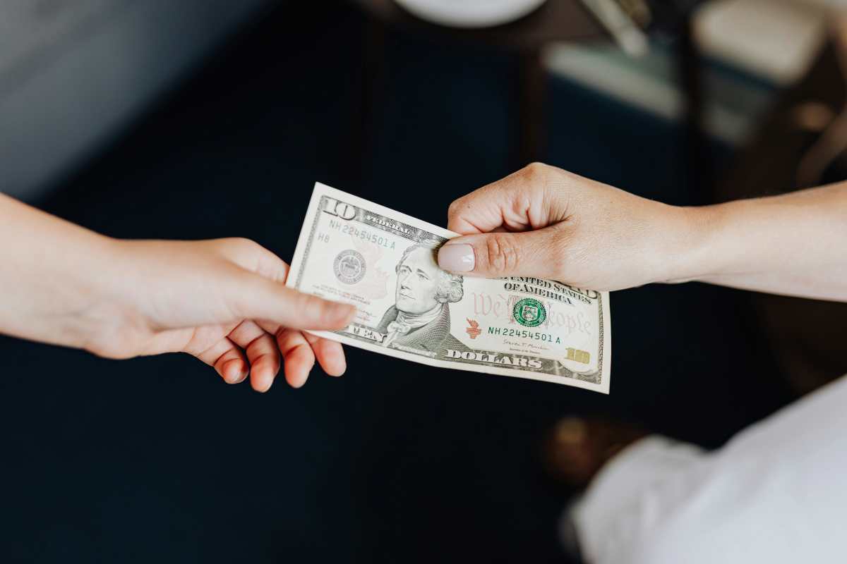 Hands holding a 10 dollar bill - Representative Image Source: Pexels | Kaboompics.com